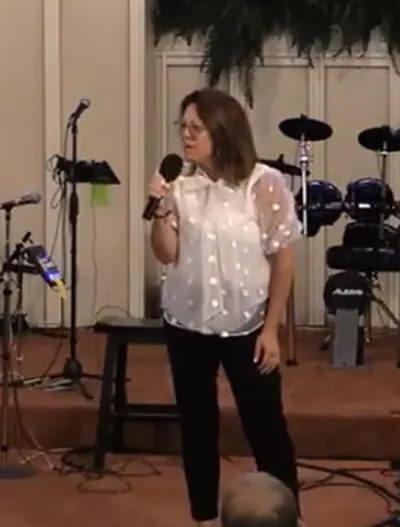 Christine Leeviraphan speaking with a microphone on a platform